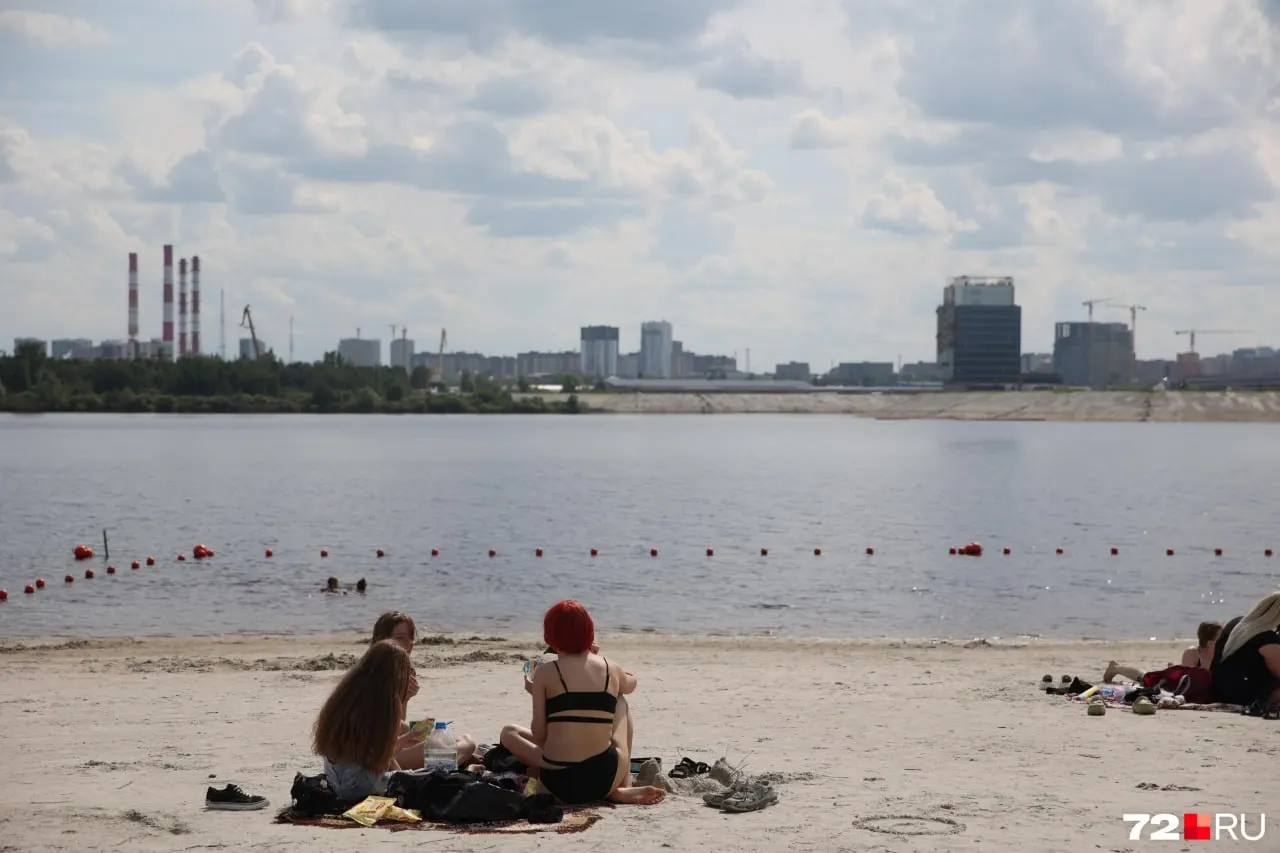 Песок, подсыпанный в прошлом году, обнажился при снижении уровня воды — на белом берегу уже собрались отдыхающие, некоторые купаются.
