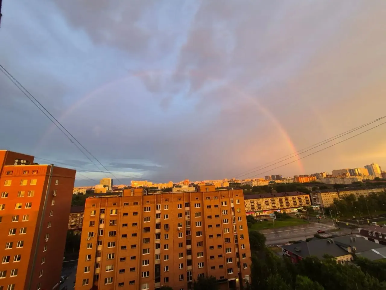 После утреннего дождя над городом появилась яркая радуга, а к вечеру небо окрасилось в розово-оранжевые и золотистые тона.